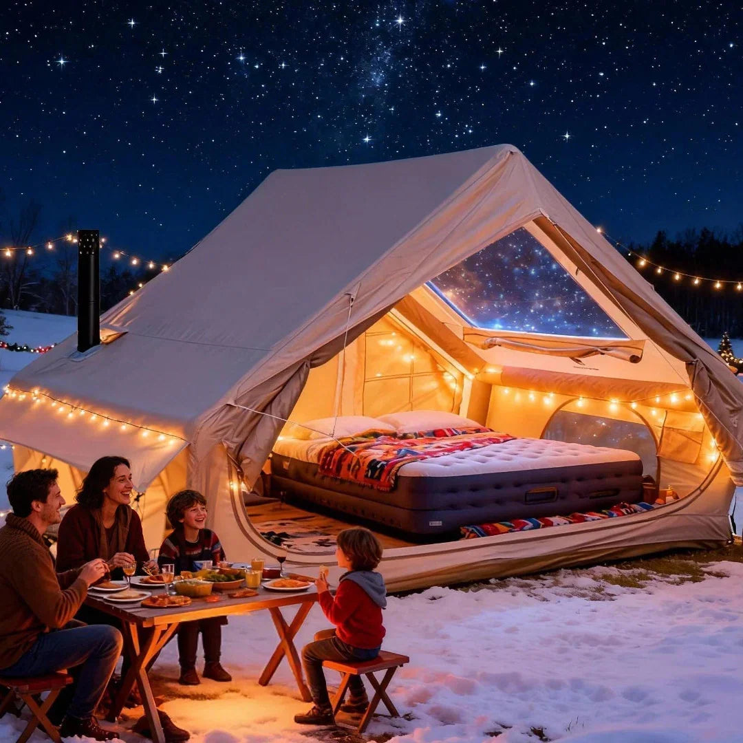 Family enjoying outdoor meal at wooden table beside illuminated canvas tent with air mattress bed in snowy night